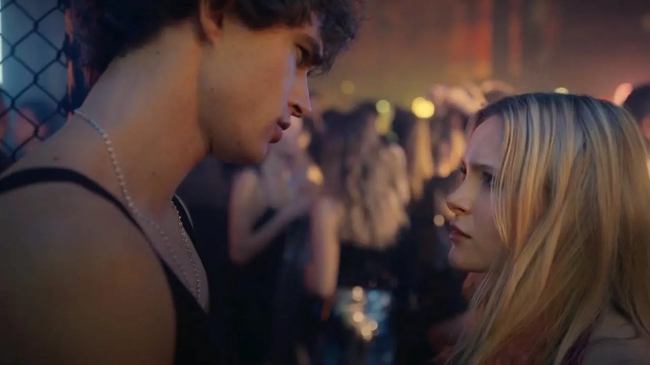 love me love me Mia Jenkins e Pepe Barroso trocam olhares tensos em uma festa de luxo na Itália no filme Love Me, Love Me