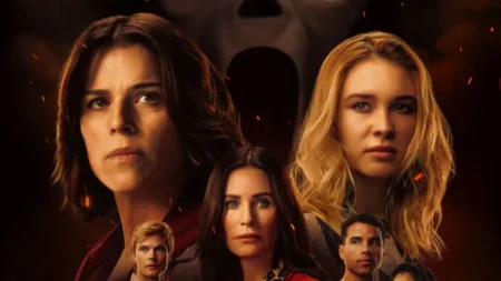 A atriz Neve Campbell com o rosto assustado enquanto protege sua família do assassino mascarado Ghostface no filme Pânico 7