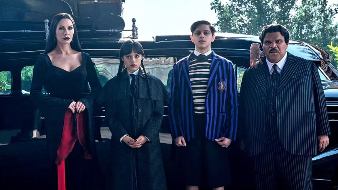 Wandinha Wandinha Addams em Nevermore, com expressão fria, cercada por vitrais e sombras, sugerindo mistério e ameaça.