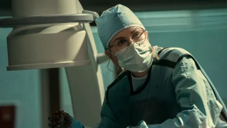 Scarpetta temporada 2 no Prime Video: o que esperar dos novos casos Kay Scarpetta de jaleco em um necrotério, com expressão cansada, enquanto luzes frias destacam o clima de suspense.