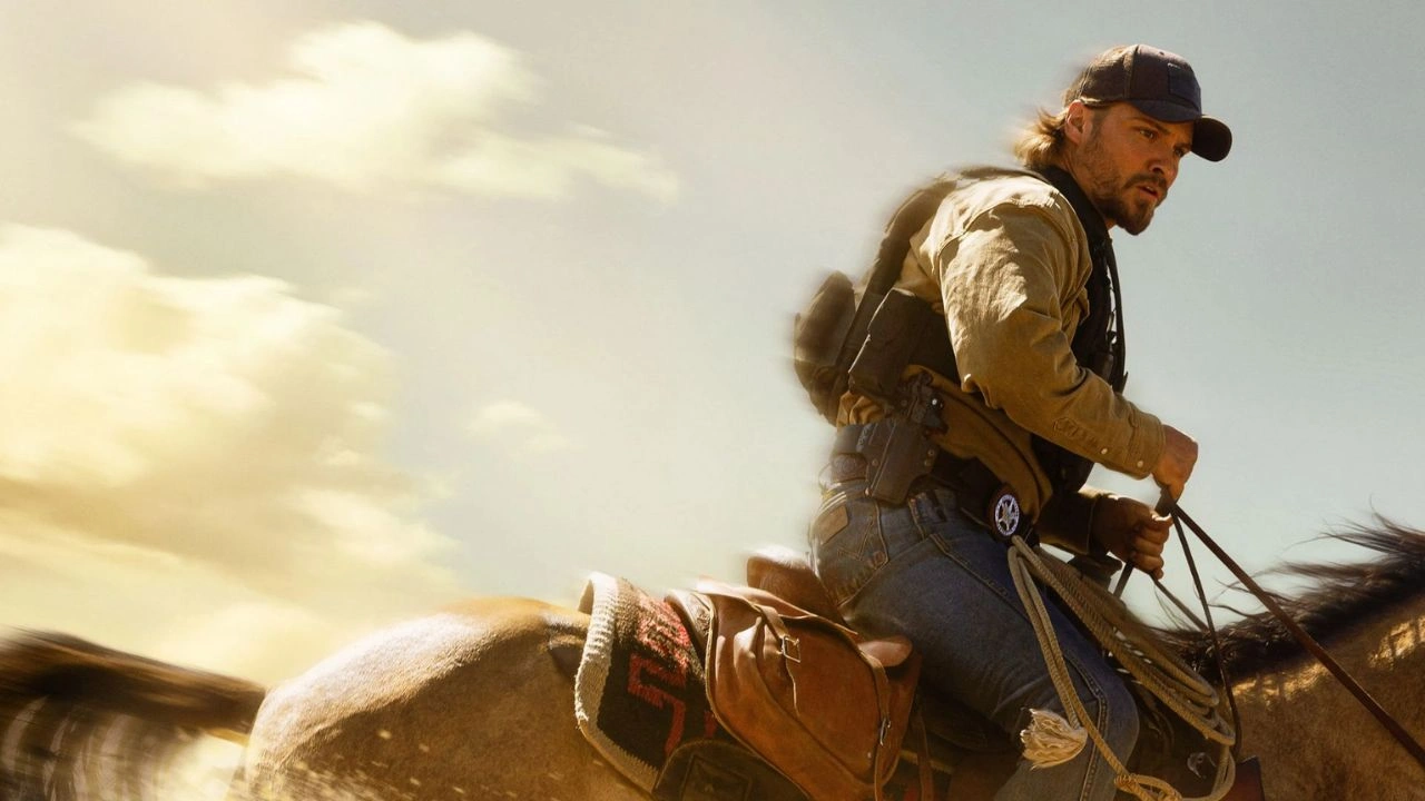 Marshals: Uma História de Yellowstone Kayce Dutton com colete tático em uma área rural escura de Montana, com sirenes ao fundo, sugerindo operação contra bomba em Marshals: Uma História de Yellowstone.