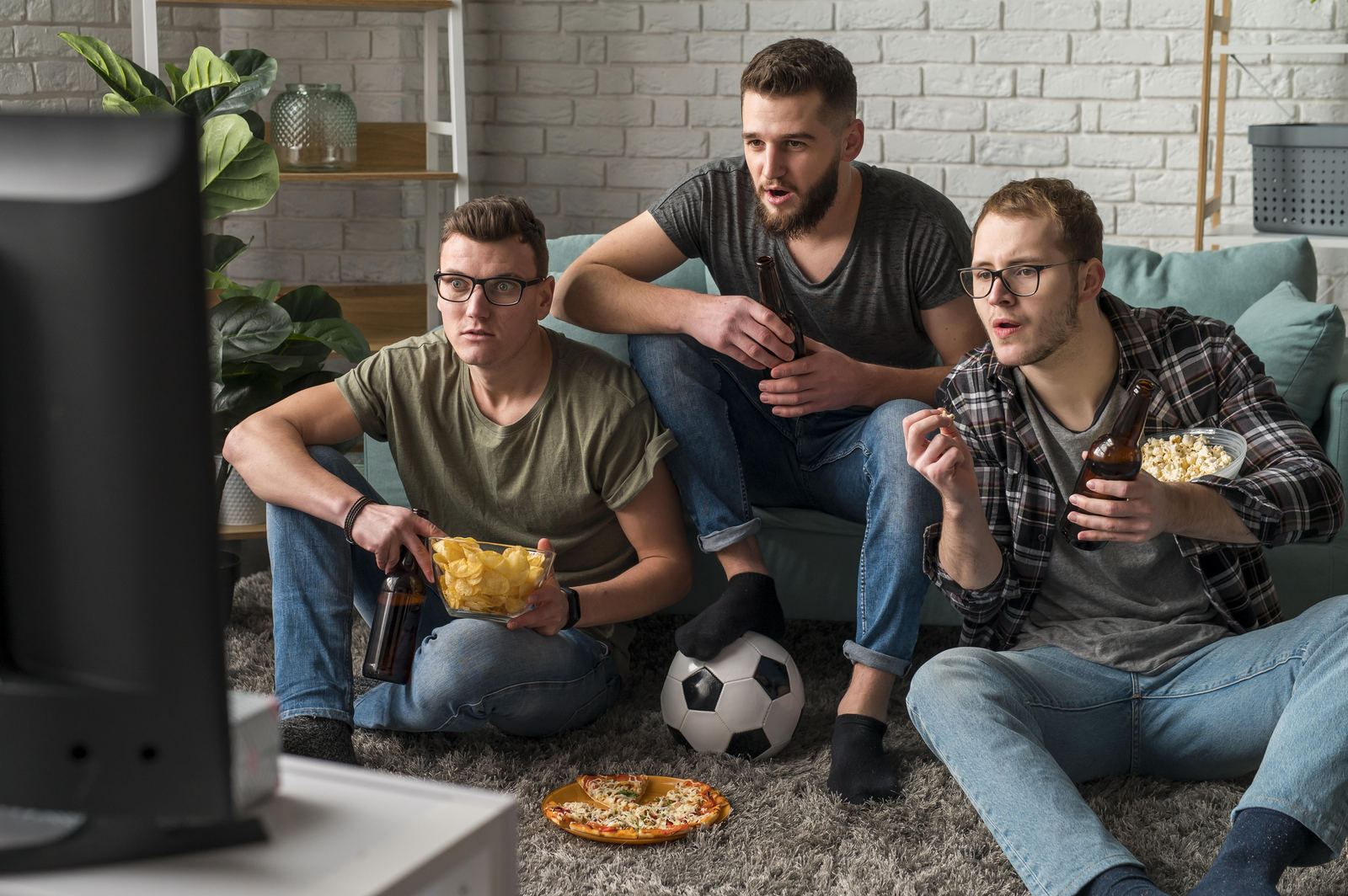 Amigos assistindo a um jogo de futebol ao vivo na TV, horário de pico de uso da internet